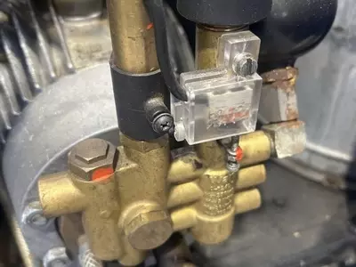 Original Nilfisk Alto unloader valve setup prior to conversion work. Due to extremely heavy daily usage and constant trigger cycling, the customer was experiencing premature unloader wear, leading to the decision to convert the machine to a VB9-style syst